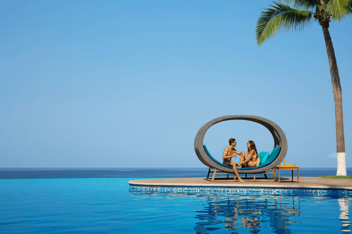 Pareja relajándose en la alberca infinita de Krystal Grand Nuevo Vallarta.